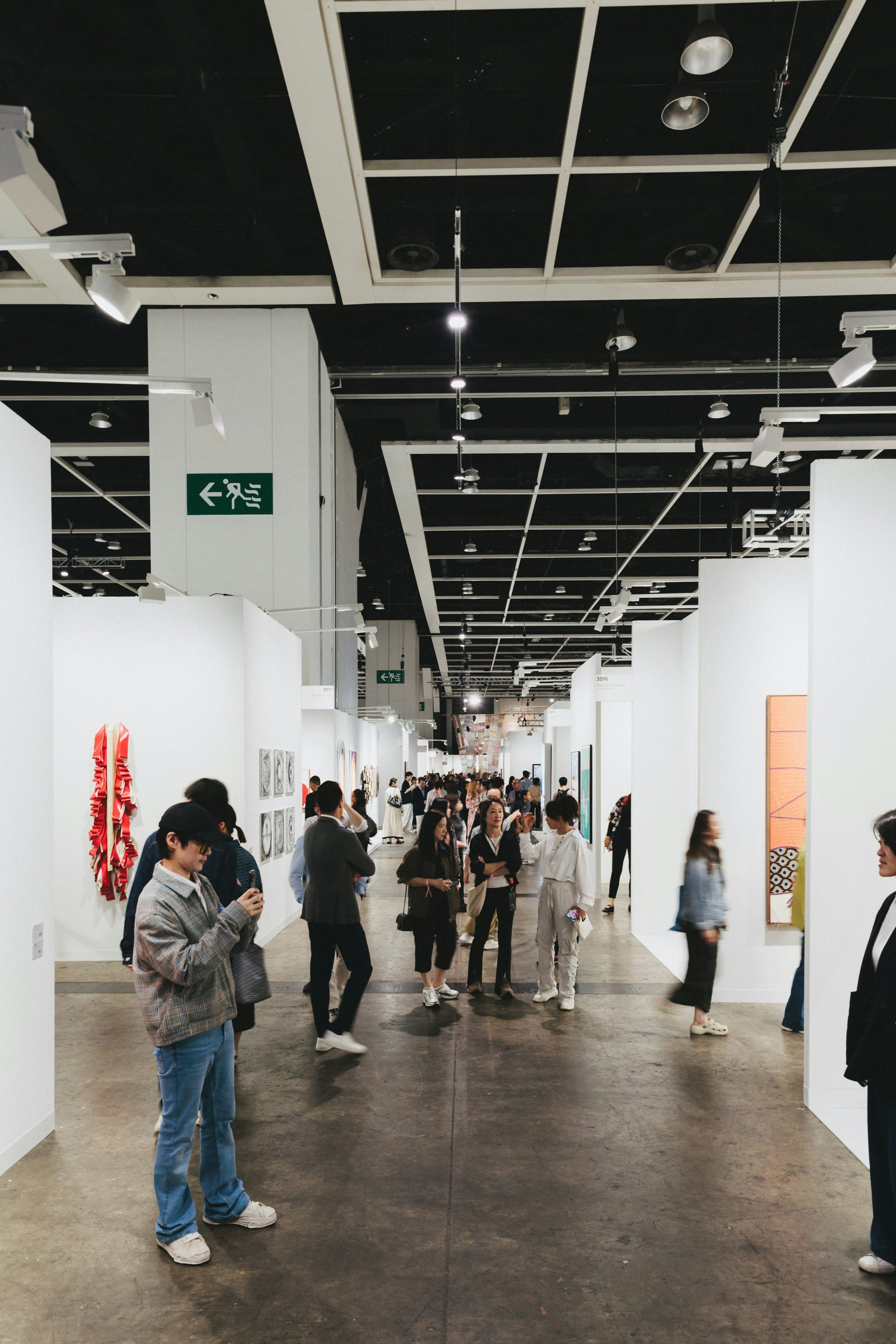 Collectors browsing booths at international art fair during market downturn debate