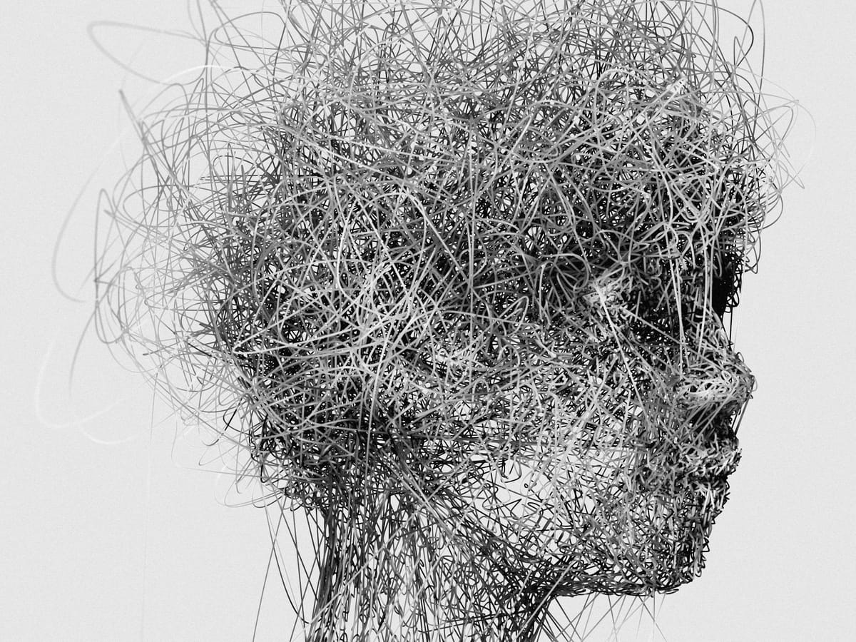 Abstract human head formed from tangled lines, suggesting cognitive overload and mental pressure.