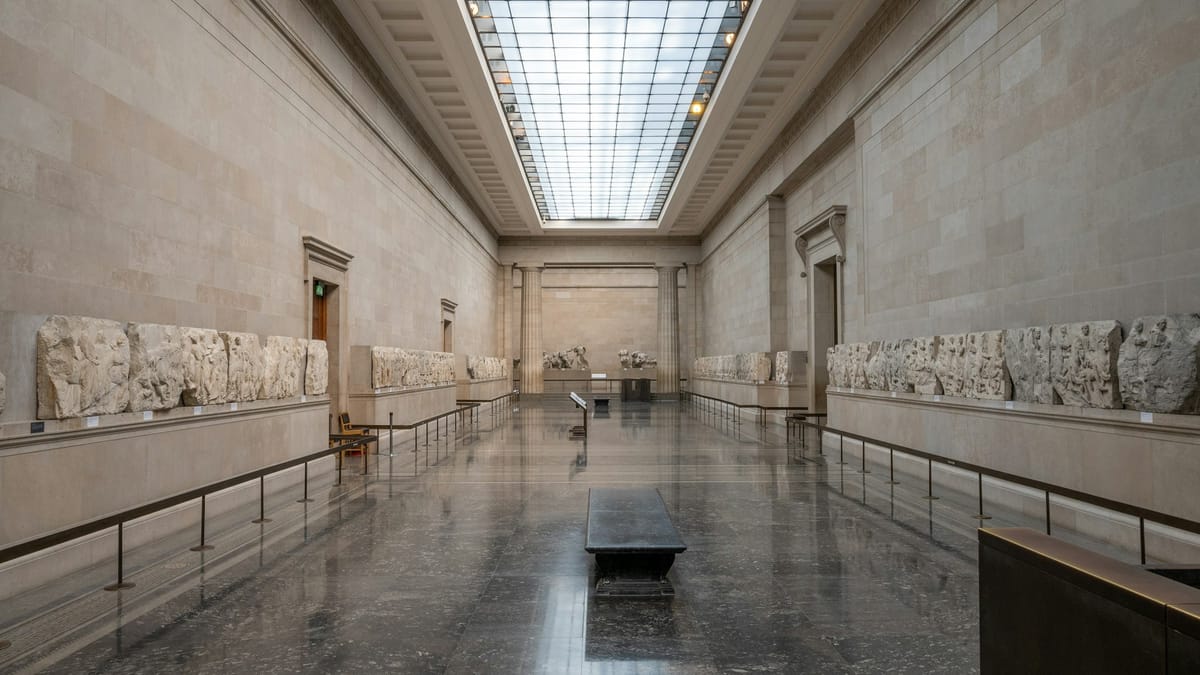 Interior view of the British Museum gallery with antiquities on display, highlighting classical sculptures and architectural space.