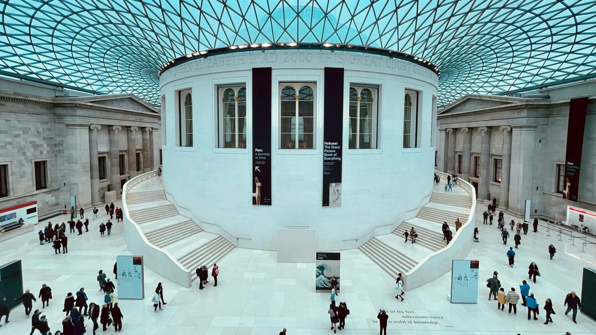 The British Museum in London with visitors near the main entrance.