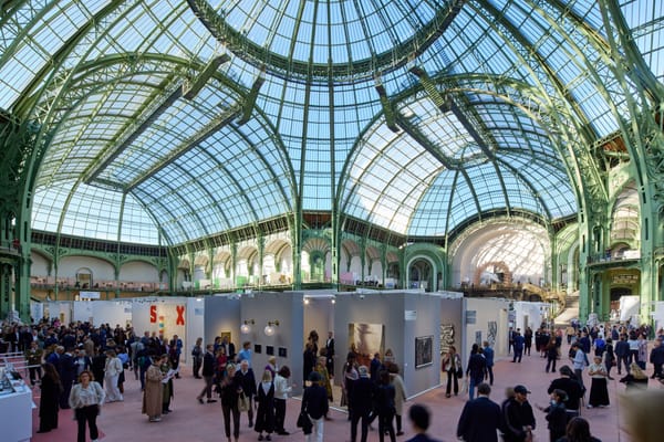 A wide-angle view of the Grand Palais, with its glass-domed ceiling and expansive hall.