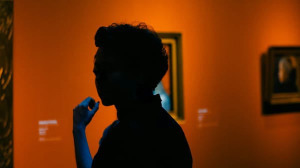 Under the gallery lights, a person confront silence, reflection, and the pulse of painted art.